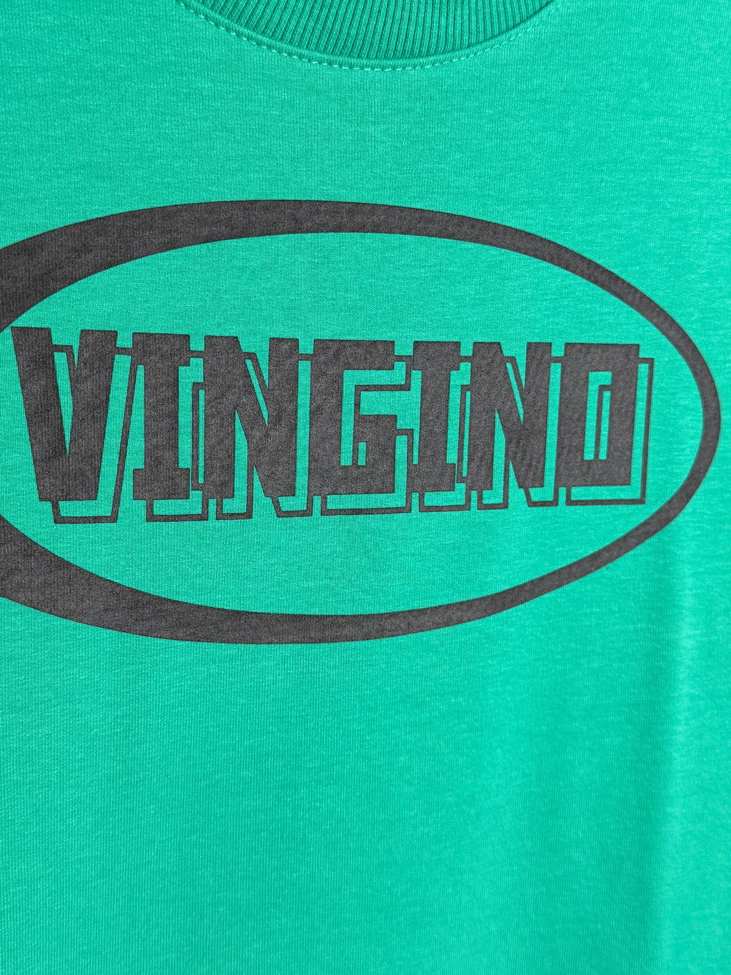 Teal t-shirt with black 'Vancity' logo on a teal background