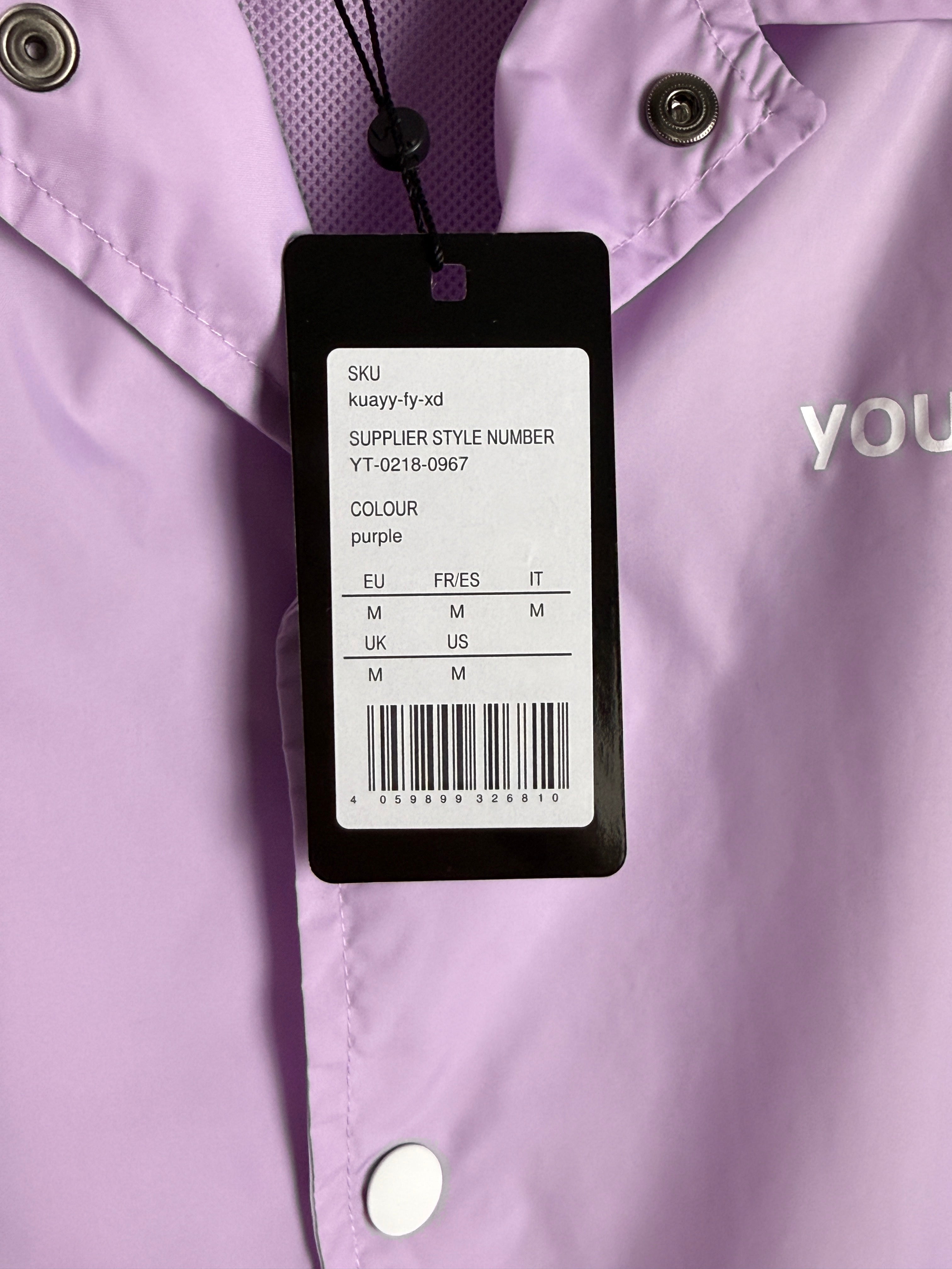 Close-up of a clothing tag on a purple garment with visible brand name.