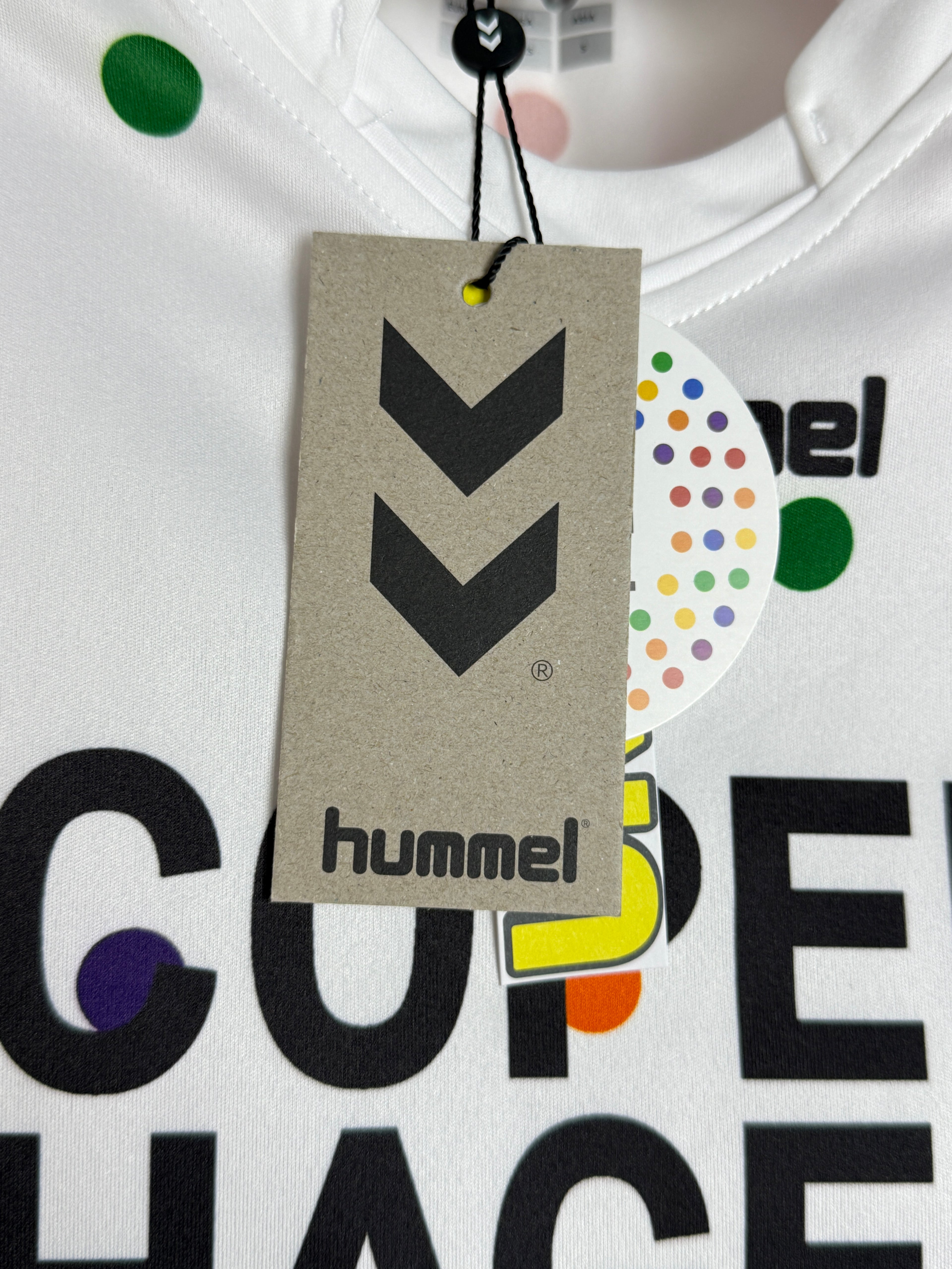Hummel tag on a product with colorful branding elements in the background