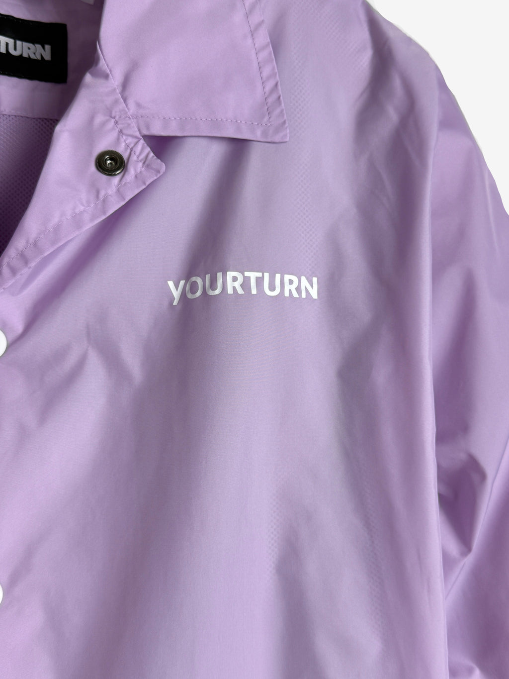 Purple shirt with 'YOURTURN' branding on a light purple background